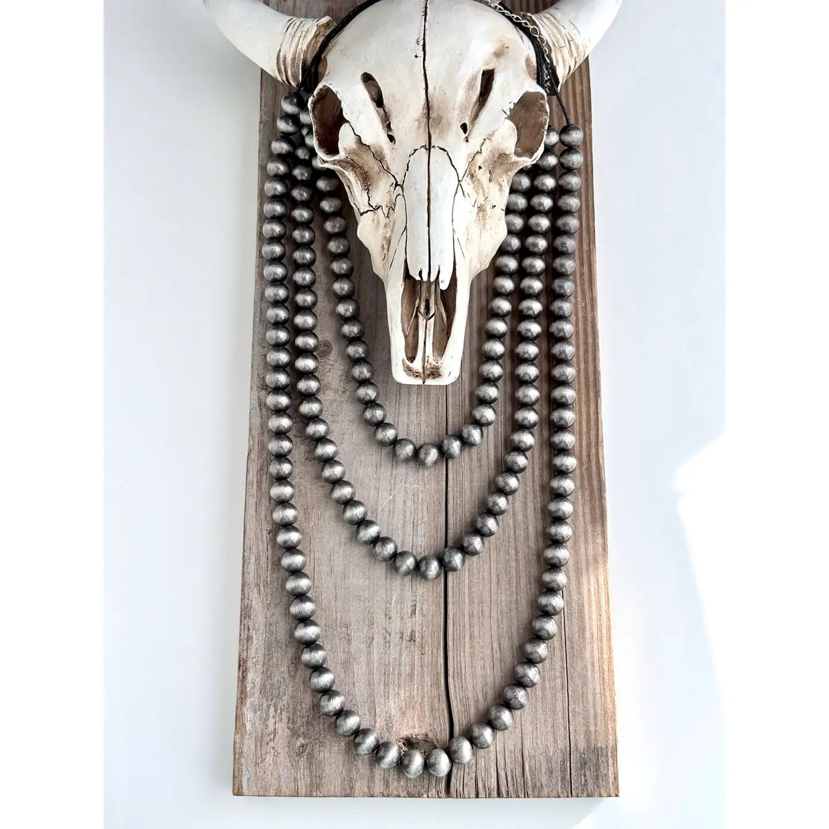 3 Layered Western Style 10mm Navajo Pearl Bead Necklace• Size: 19" + 3"L• Lobster Claw Clasps• Brushed Silver, 10mm Navajo Pearl Bead