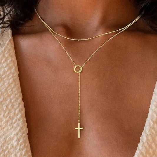 18K Stainless Steel Tarnish-Free Cross Charm Necklace. Crafted from high-quality stainless steel with an 18K gold finish, this necklace is designed to resist tarnish and maintain its brilliance. Featuring cross on end of delicate Y-shaped drop. Perfect gift for the holidays,