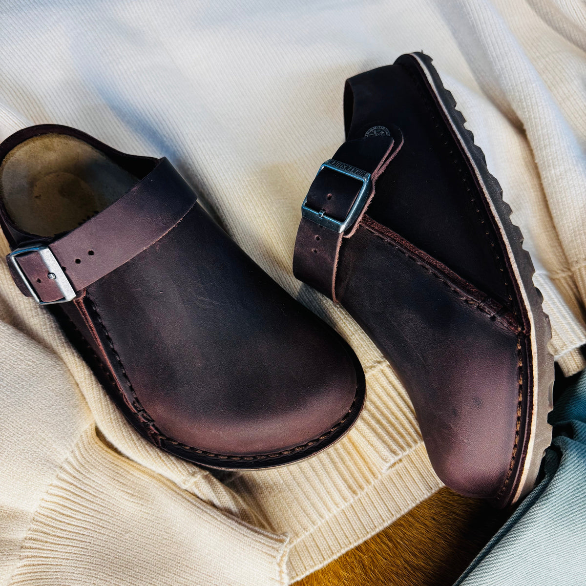 The BIRKENSTOCK Lutry is a slipper that can be worn as a backstrap style or as an open clog thanks to the flexible ankle strap. The footbed can be removed, for you to choose between three different footbed versions. This basic version features our standard footbed. It replicates the natural print made by a foot walking on sand and will see you through the day in comfort. The upper is made from extra thick, oiled nubuck leather with an open-selvage finish.