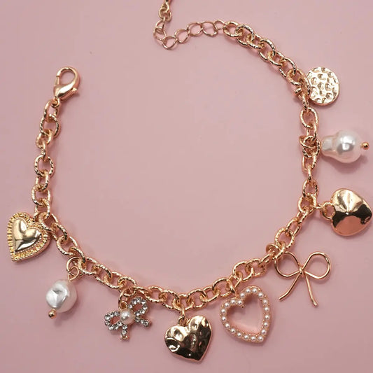 This Charm Bracelet features a delightful mix of bow, heart, pearl, and disc charms, offering a perfect blend of elegance and charm. The playful design makes it a versatile accessory, ideal for both casual and dressy looks. Lightweight and stylish.